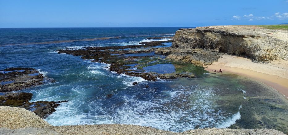 Panormaic view of Little Bay taken from the clifftop, showing the tidepools and towering cliffs